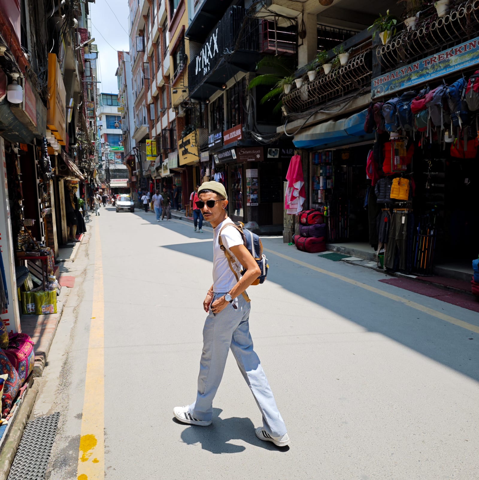 Wafi walking across a street of shops in Thamel, Kathmandu.